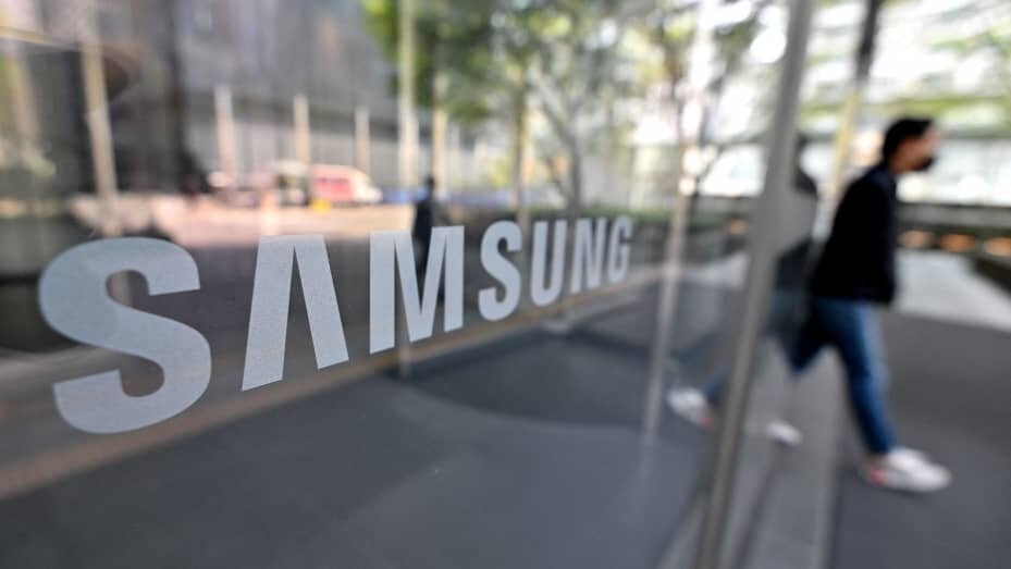 Мужчина проходит мимо логотипа Samsung, размещенного на стеклянной двери в здании компании Seocho в Сеуле 7 апреля 2023 года.