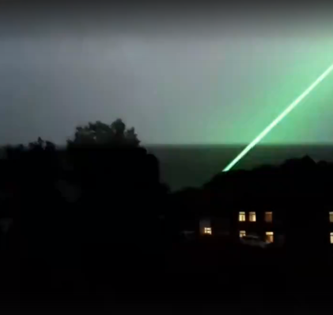 Скрин из видео, где во время шторма зелёный луч ударяет в землю после яркой вспышки. Гавайи, 2023 год.