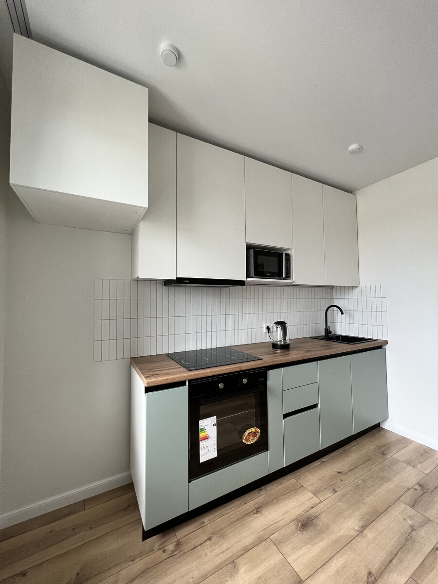 Использование контраста, белый фартук в плитке и столешница под дерево