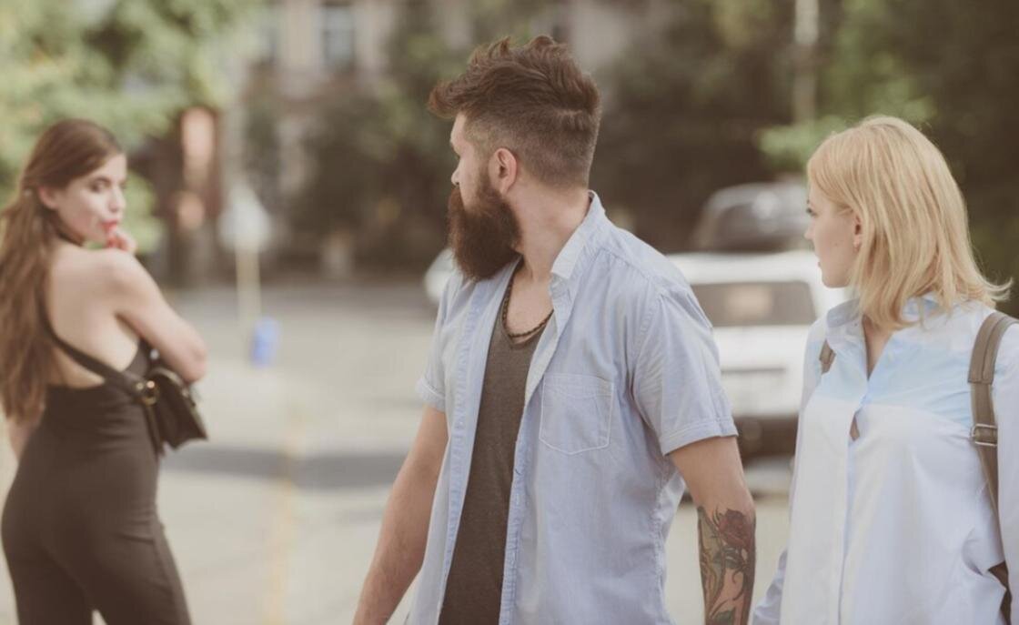    Несвободный парень оглядывается на другую девушку:Freepik