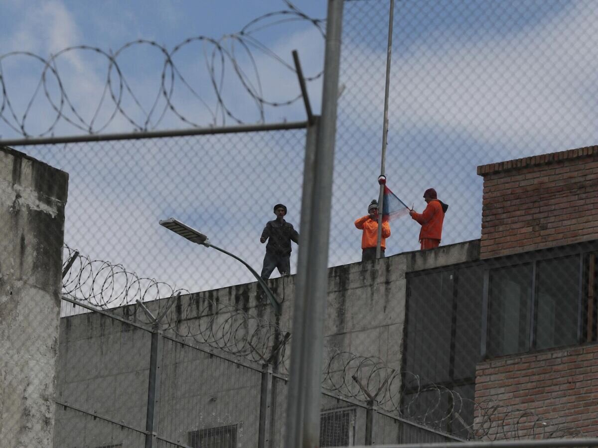    Заключенные на крыше тюрьмы Тури в городе Куэнке, Эквадор, во время начавшихся беспорядков© AP Photo / Xavier Caivinagua