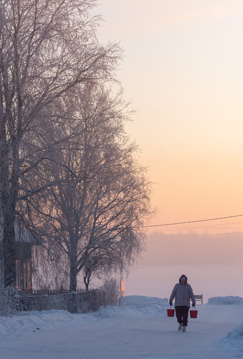 Женщина несет воду на рассвете