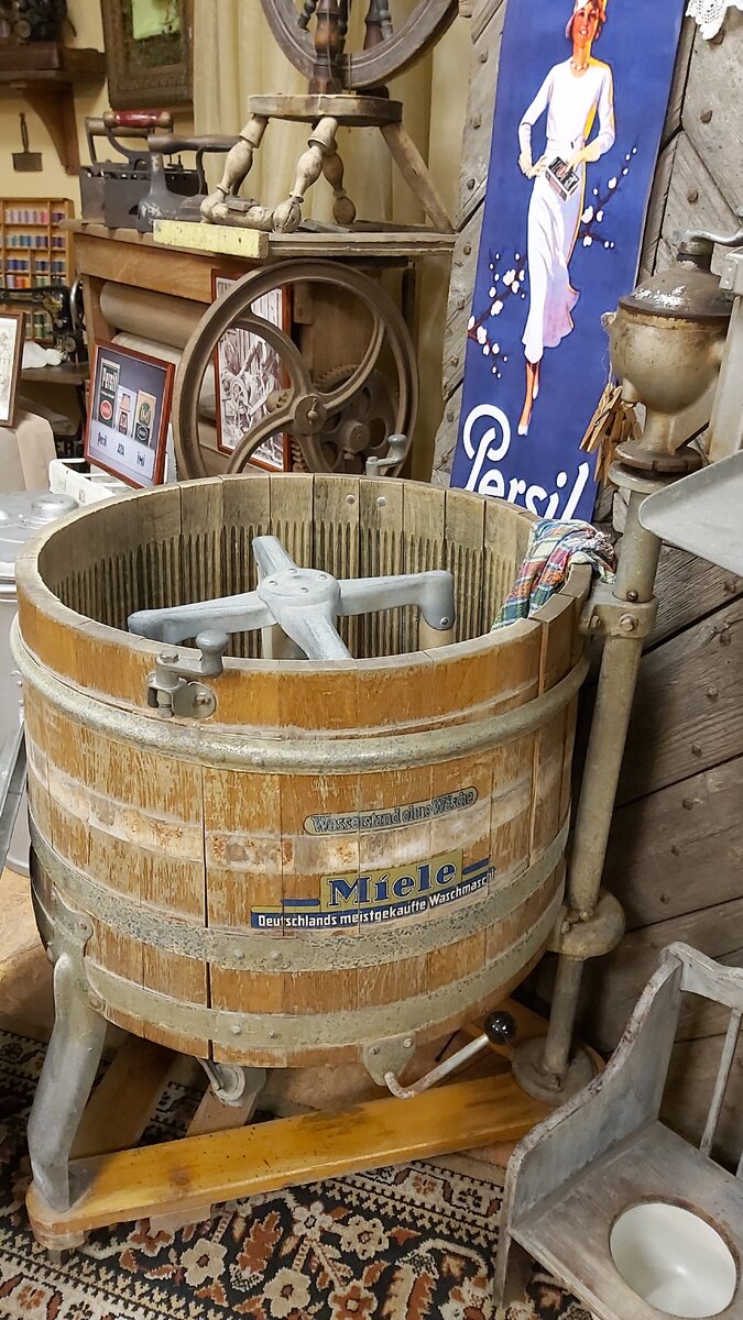 Стиральная машинка Miele, а за ней - реклама Persil