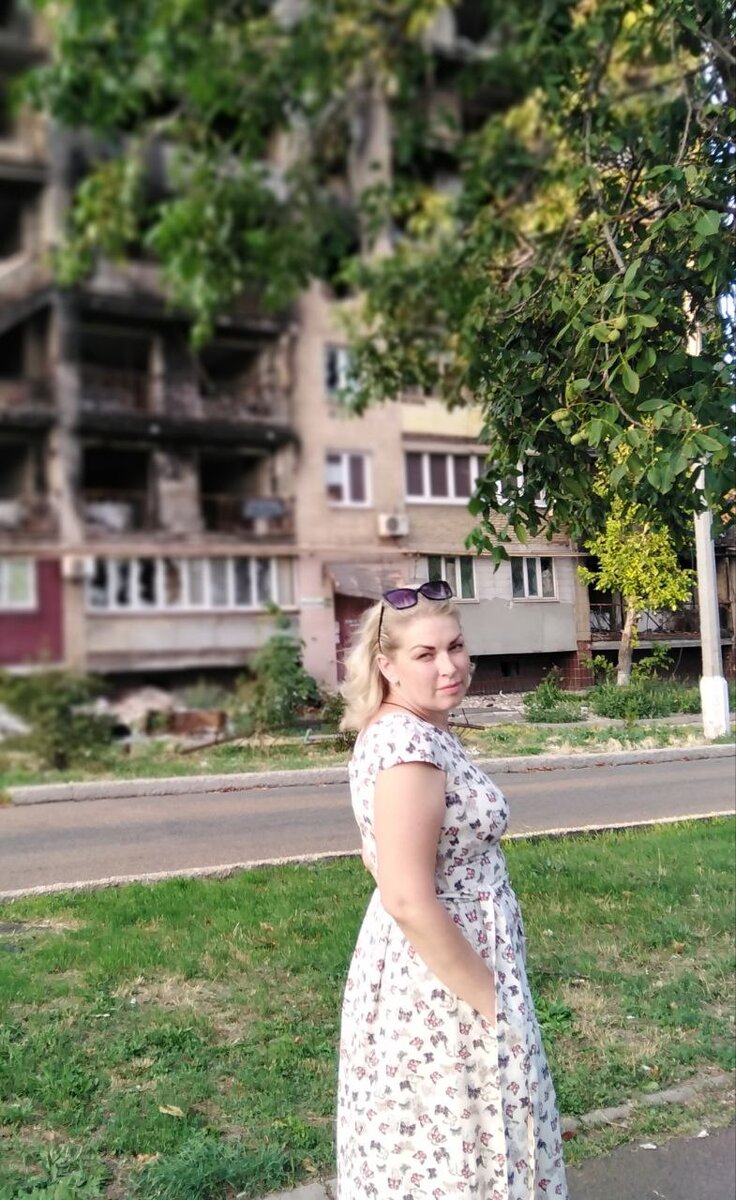 Аня на фоне полусгоревшего дома 