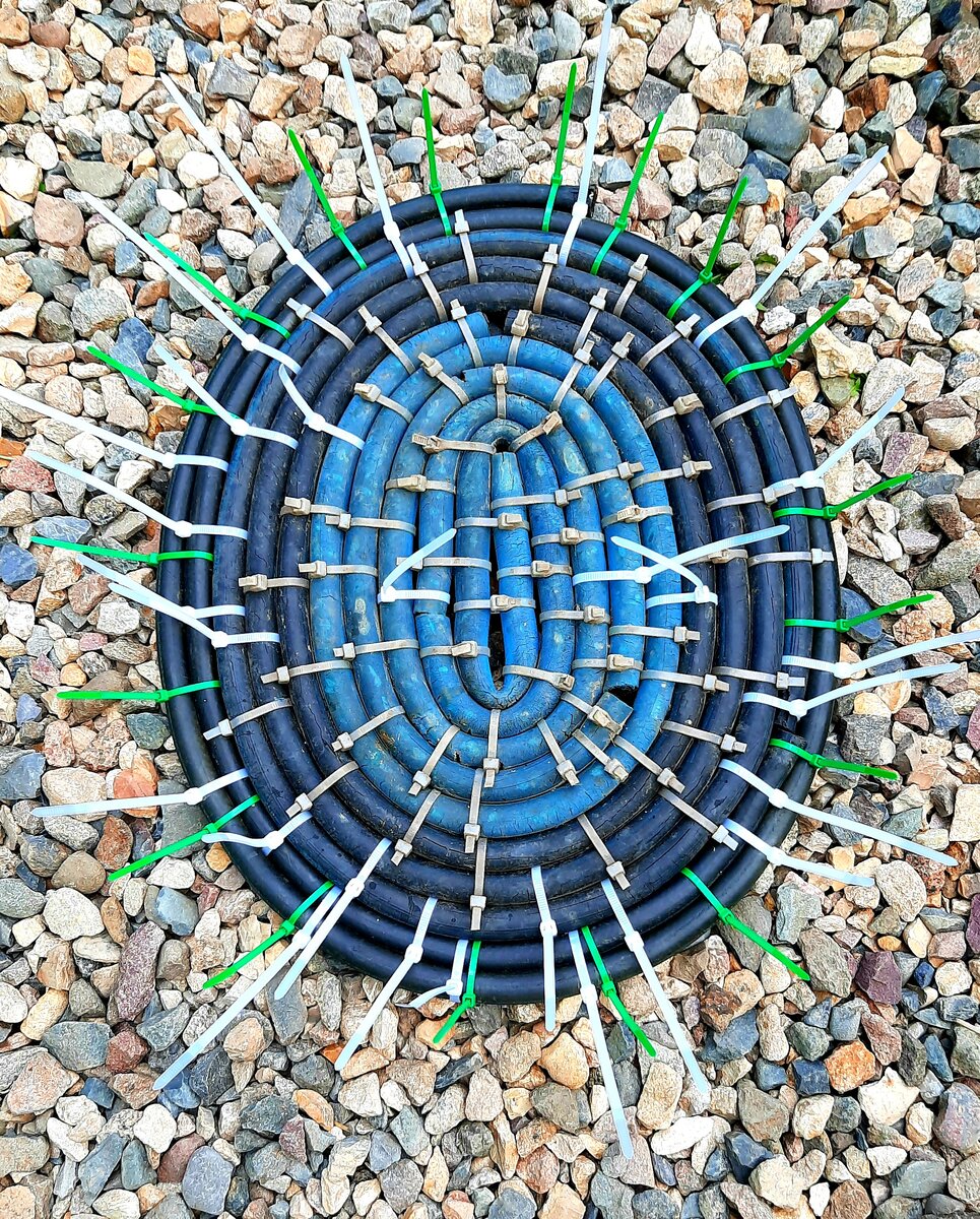 Фото автора. Коврик из шлангов и хомутов с изнанки.