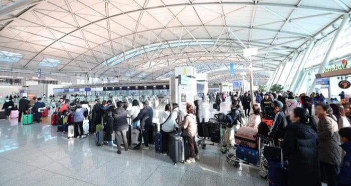    Люди стоят в очереди к стойке регистрации в первом терминале международного аэропорта Инчхон, чтобы попасть на рейсы, вылетающие из страны, 5 января. Yonhap