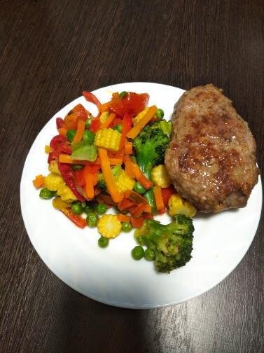 Котлета и овощи приготовлены в духовке.