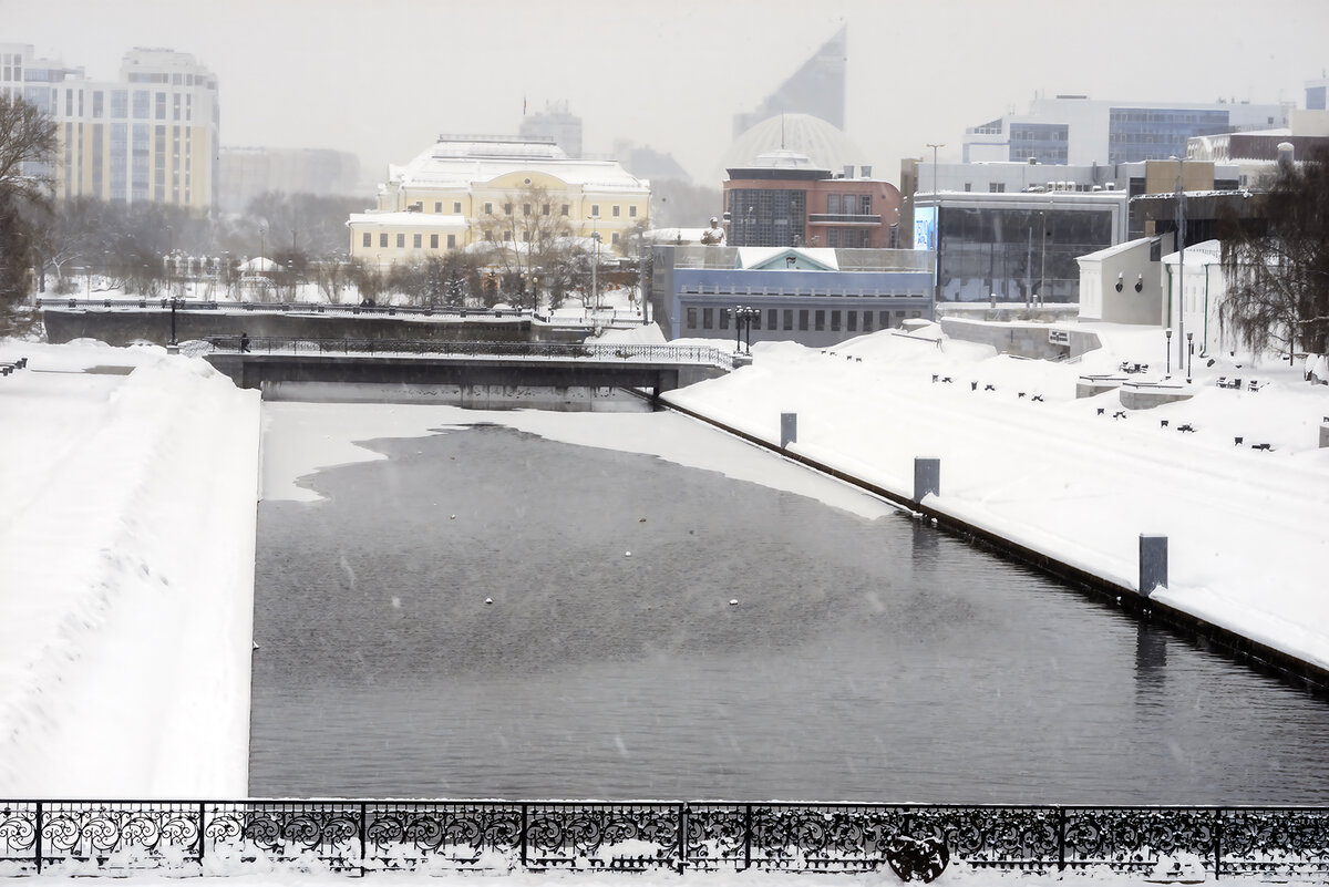 На данном снимке морозная погода и мелкий снег делает цветовую гамму более однородной, а контуры объектов размываются. Тут также присутствует линейная перспектива, которая создает эффект присутствия за счет художественной оградки на мостике через реку на переднем плане.