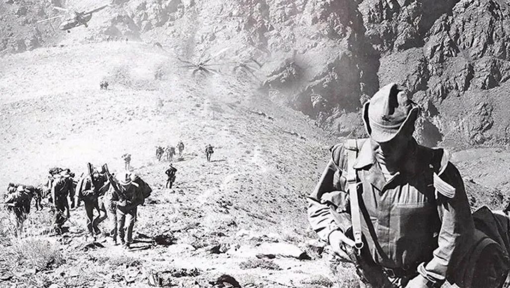 Очень интересный снимок из Афгана тех времен. На переднем плане Советский офицер - десантник, он надел на себя прикид солдата, но его выдает офицерская портупея и грозный командирский вид. Под Х/Б у офицера легкий бронежилет, который спасет только от пистолетной пули и холодного оружия. В тяжелом бронежилете на эту гору вообще не поднимешься. Столько лет прошло и Афганская кампания воспринимается как жестокий эксперимент над собственной страной и народом, а также над Афганским племенным населением. Фото из открытого источника.