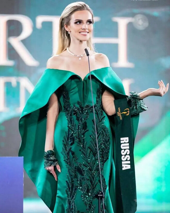    В один из конкурсных дней Дарья блистала в изумрудном платье со шлейфом и напоминающие еловые ветри узором.Скриншот ютуб Miss Earth 2023.