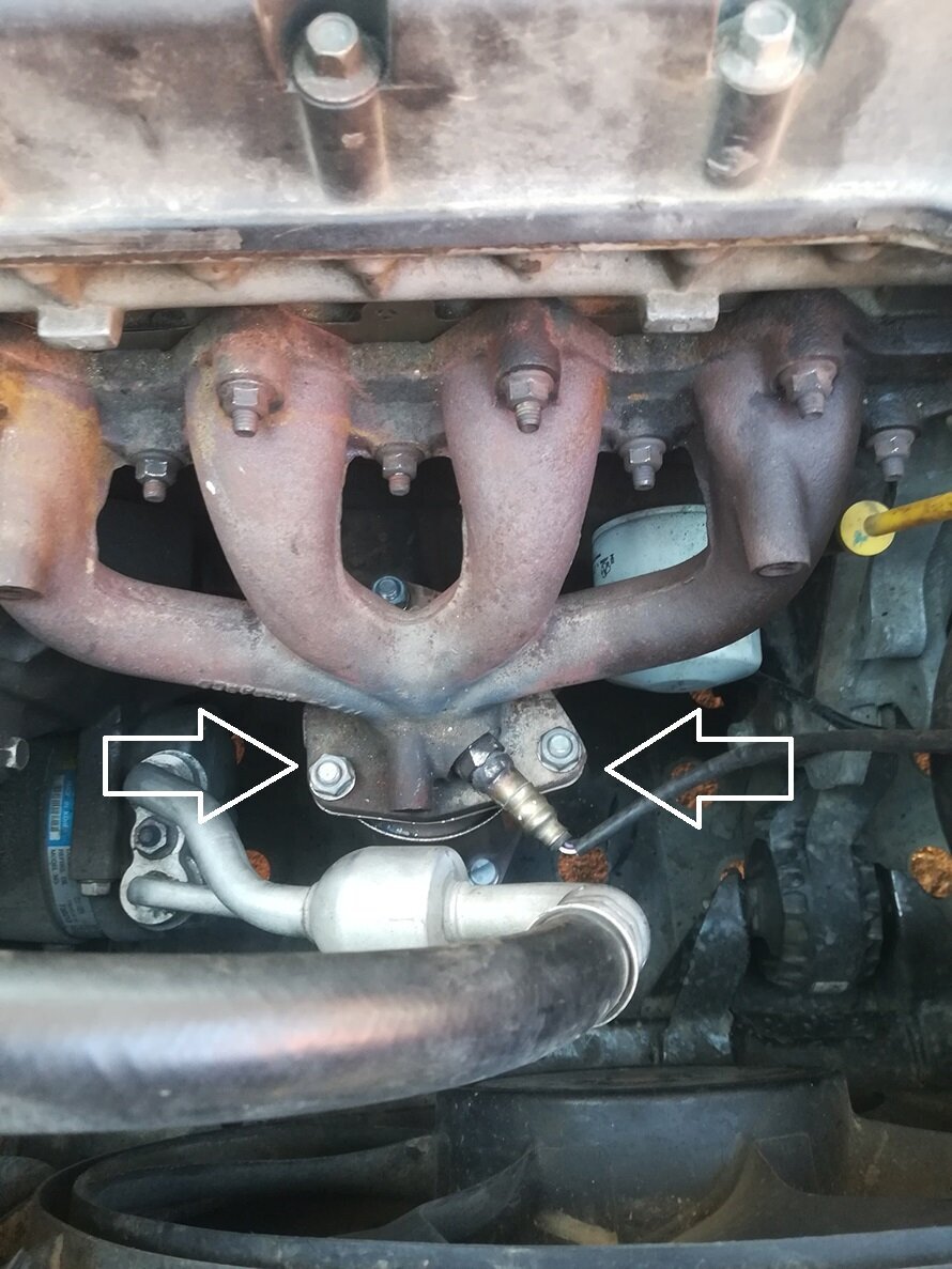 Сразу за выпускным коллектором находится катализатор (указан стрелочками). Крепится к коллектору тремя шпильками (на фото видны гайки крепления с обратной стороны).