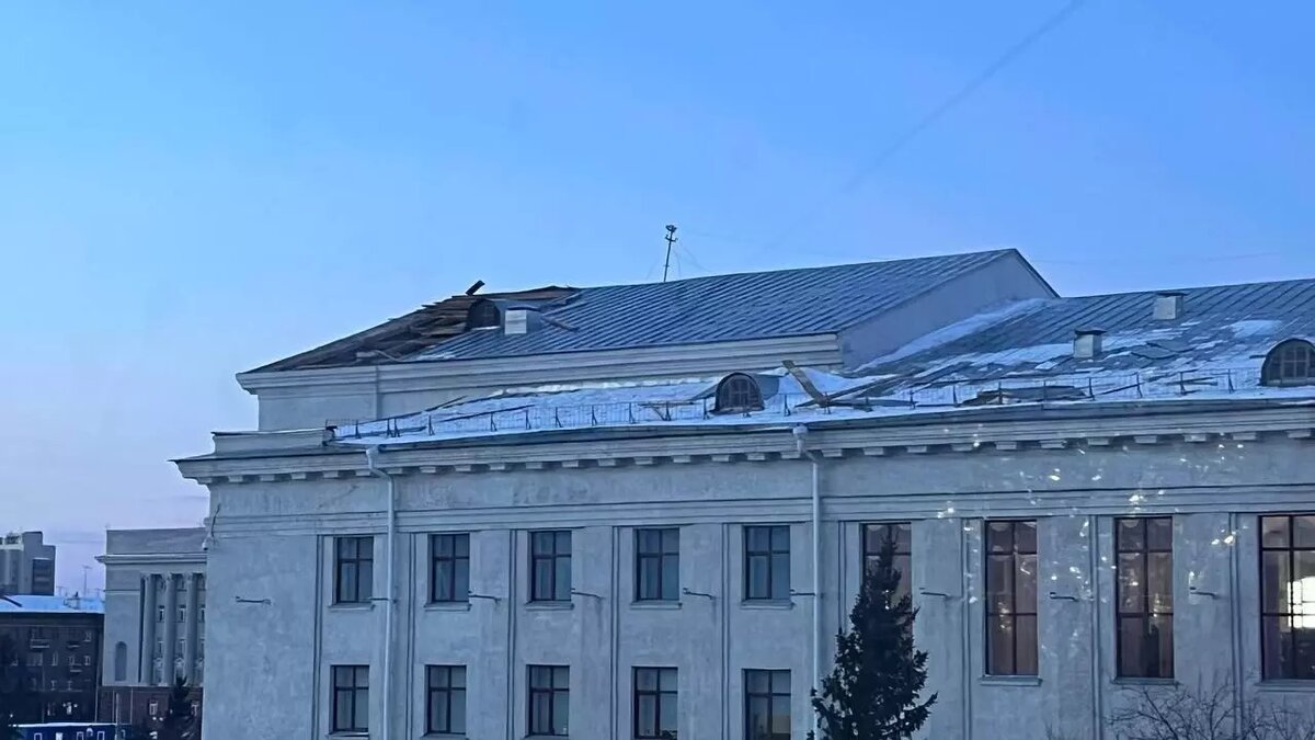     Красноярск утром 15 января накрыла метель и сильный ветер, который снес часть крыши со здания краевой библиотеки на улице Карла Маркса, 114.