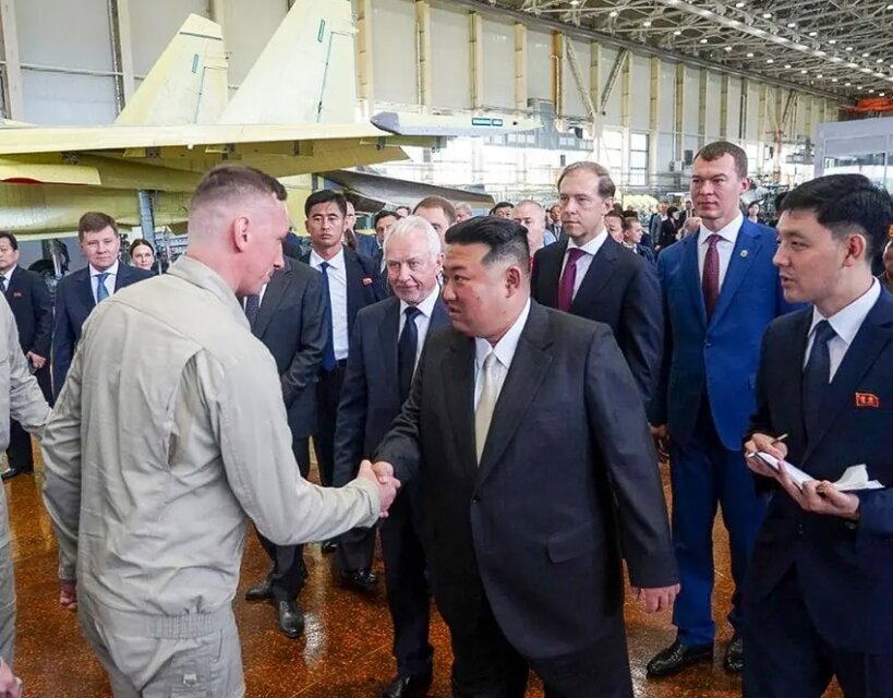 Лидер Северной Кореи Ким Чен Ын пожимает руки сотрудникам во время посещения российского авиационного завода, который производит истребители в Комсомольске-на-Амуре