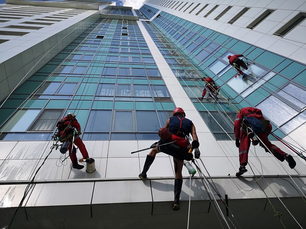 Сотрудники управляющий компания Олви моют фасад здания, литайте, еще много фото