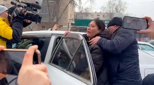 Махабат Тажибек кызы силой усаживают в автомобиль, чтобы увезти на допрос. Фото с сайта 24.kg