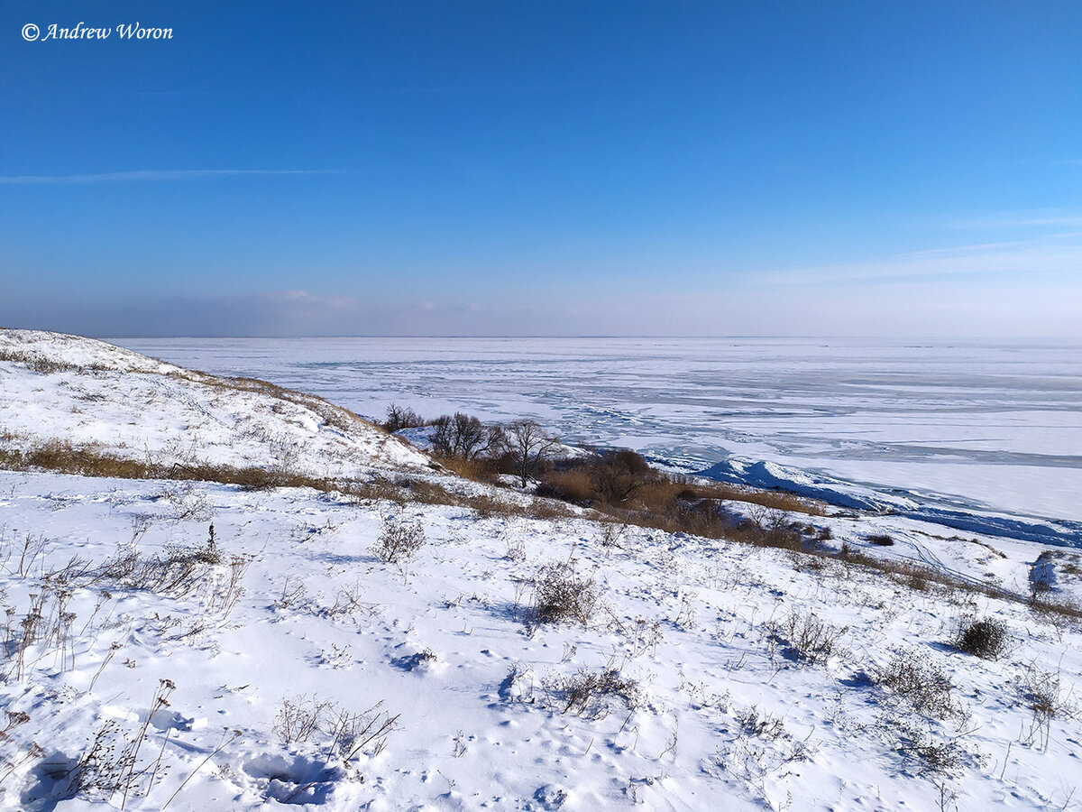 Вид со склона холма на покрытое льдом море