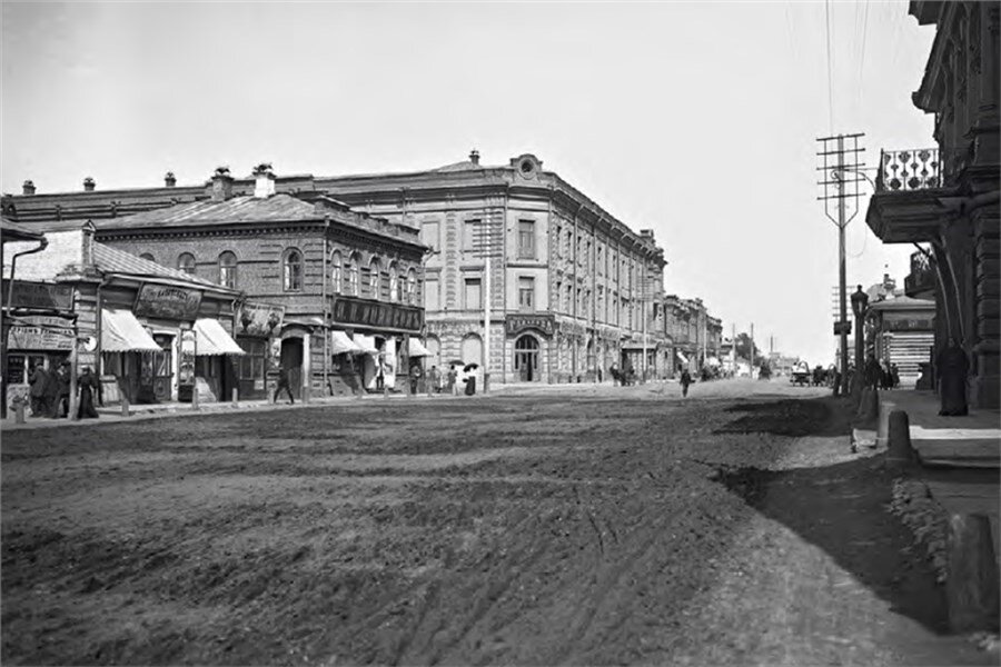 Улица Воскресенская с домом И. Г. Гадалова. По снимку 1907 года видно, что на центральной улице города грязь, но тротуары отгорожены от проезжей части Фото из альбома «Людвиг Вонаго — фотограф на выезд»