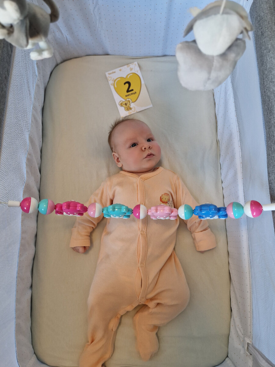 Лежит в колыбели, наблюдает за крутящимся мобилем