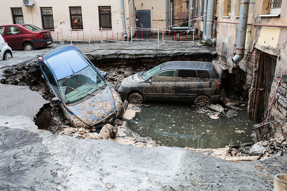 Провал грунта после прорыва трубы с горячей водой на Измайловском проспекте в 2018 году. В результате ЧП под землю провалились два автомобиля. Фото: Валентин Егоршин/ТАСС