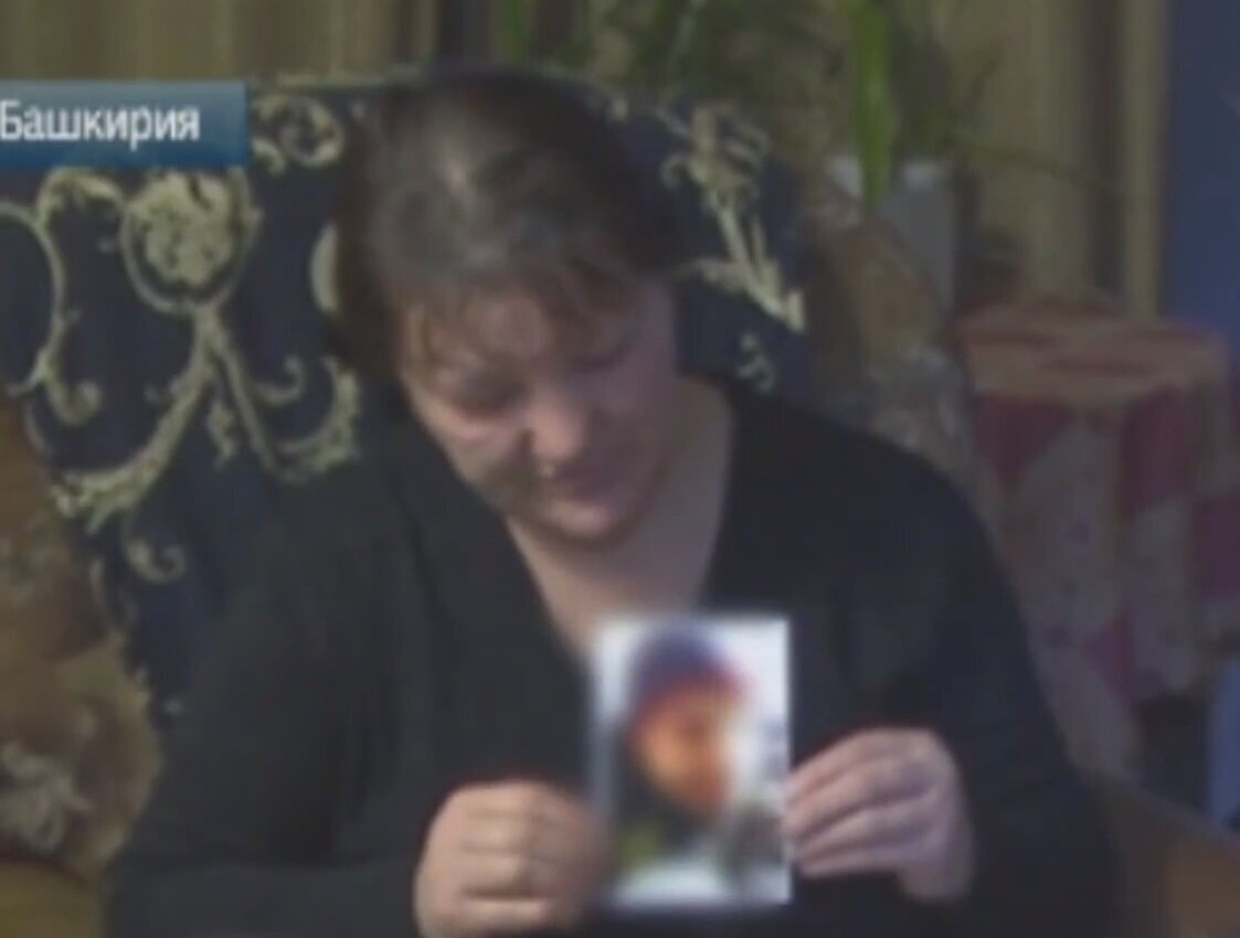 Мама Азамата с фотографией мальчика во время проходящих поисков