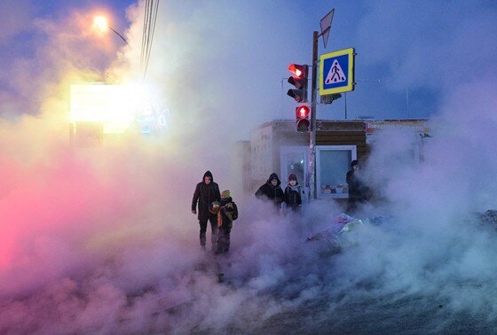    Люди обходят разлив горячей воды рядом с местом прорыва теплотрассы по улице Петропавловской в Новосибирске