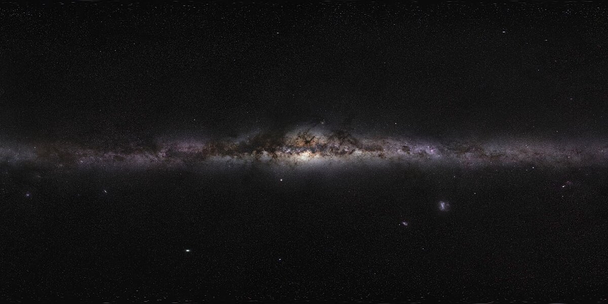 Панорама нашей Галактики – Млечного пути, как мы её видим оптическими телескопами Южно-Европейской обсерватории (ESO). Тёмные полосы, пересекающие галактический диск, наиболее отчётливо проявляющиеся в центре Галактики – протяженные комплексы газово-пылевых облаков, не позволяющие видимому свету проникать сквозь них.  (https://www.eso.org/public/images/eso0932a/) Credit: ESO/S, Brunier   