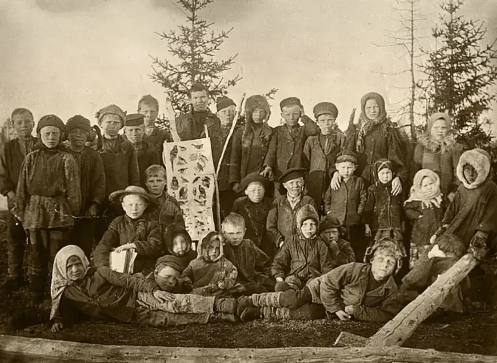 Пример учеников. “Учитель Канев с учениками местной церковно-приходской школы. Ижемцы. с. Усть-Уса (Архангельская губ., Печорский уезд). 1912 год.”. 