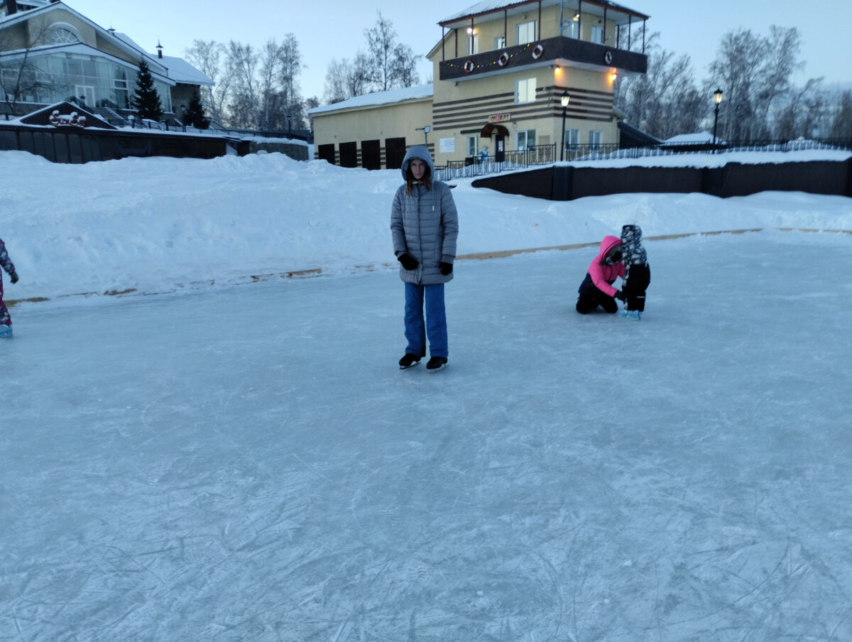На заднем плане, дочь и сын учатся кататься