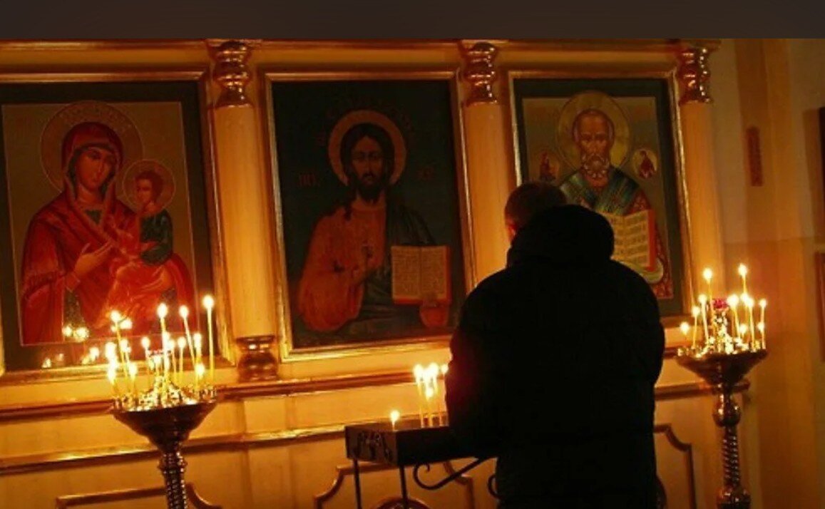 Мужчина ставит свечу. Человек молится в храме. Мужчина у иконы в храме. Чел молится в церкви. Молодой человек молится в храме.