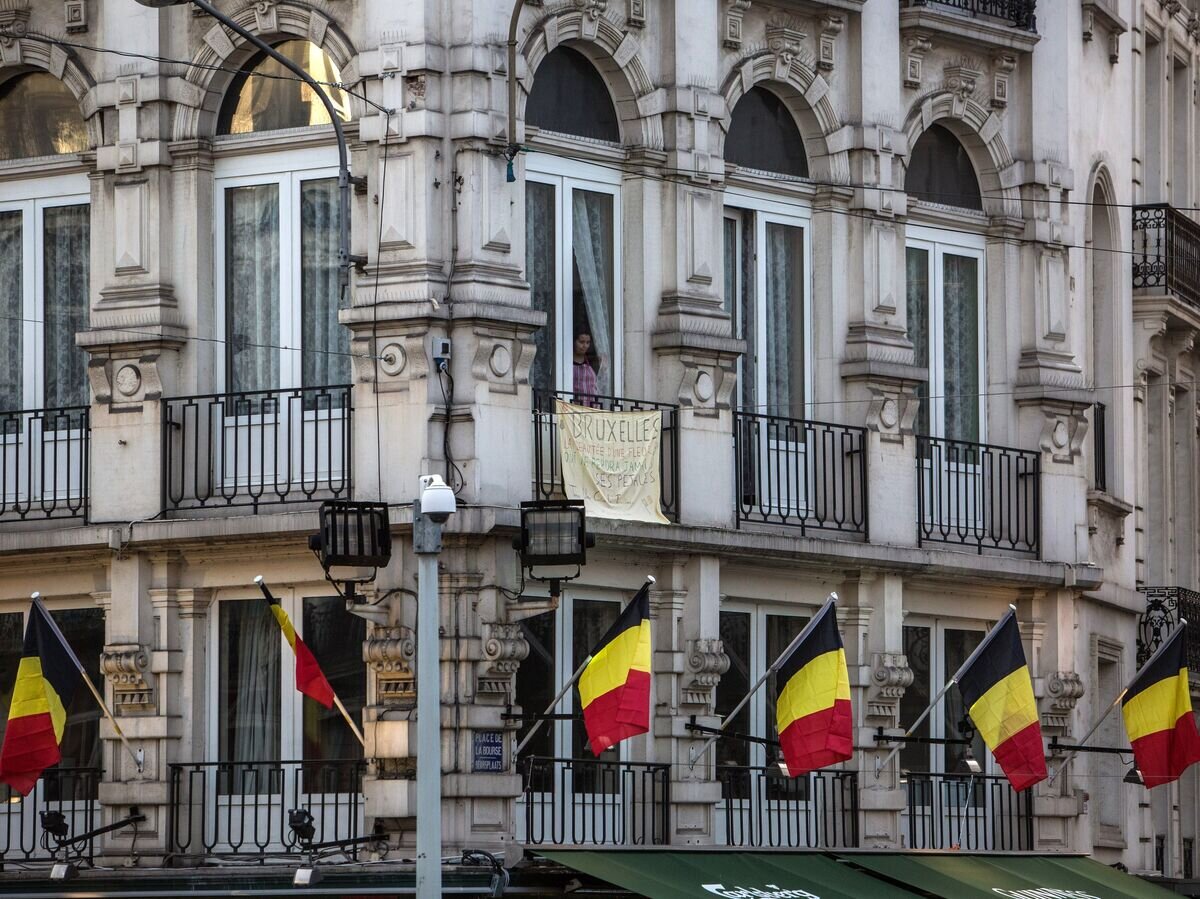    Мужчина в окне здания на Биржевой площади в Брюсселе© РИА Новости / Ирина Калашникова