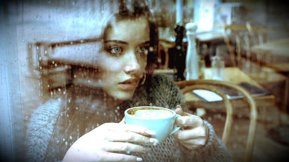 женщина пьет кофе и смотрит в окно