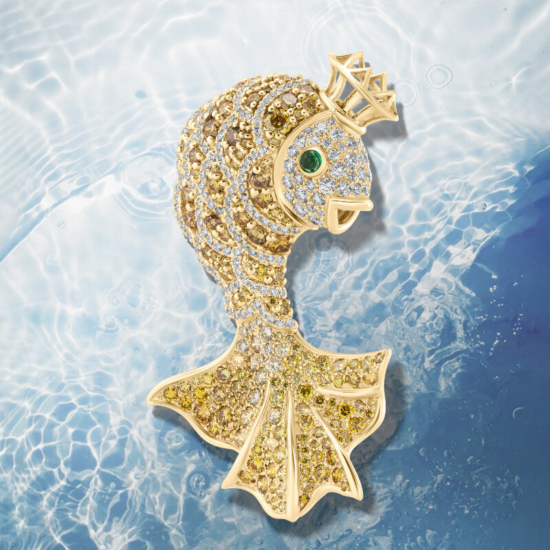 На фото: брошь Mercury Classic из желтого золота с изумрудом-кабошоном, прозрачными и желтыми бриллиантами 