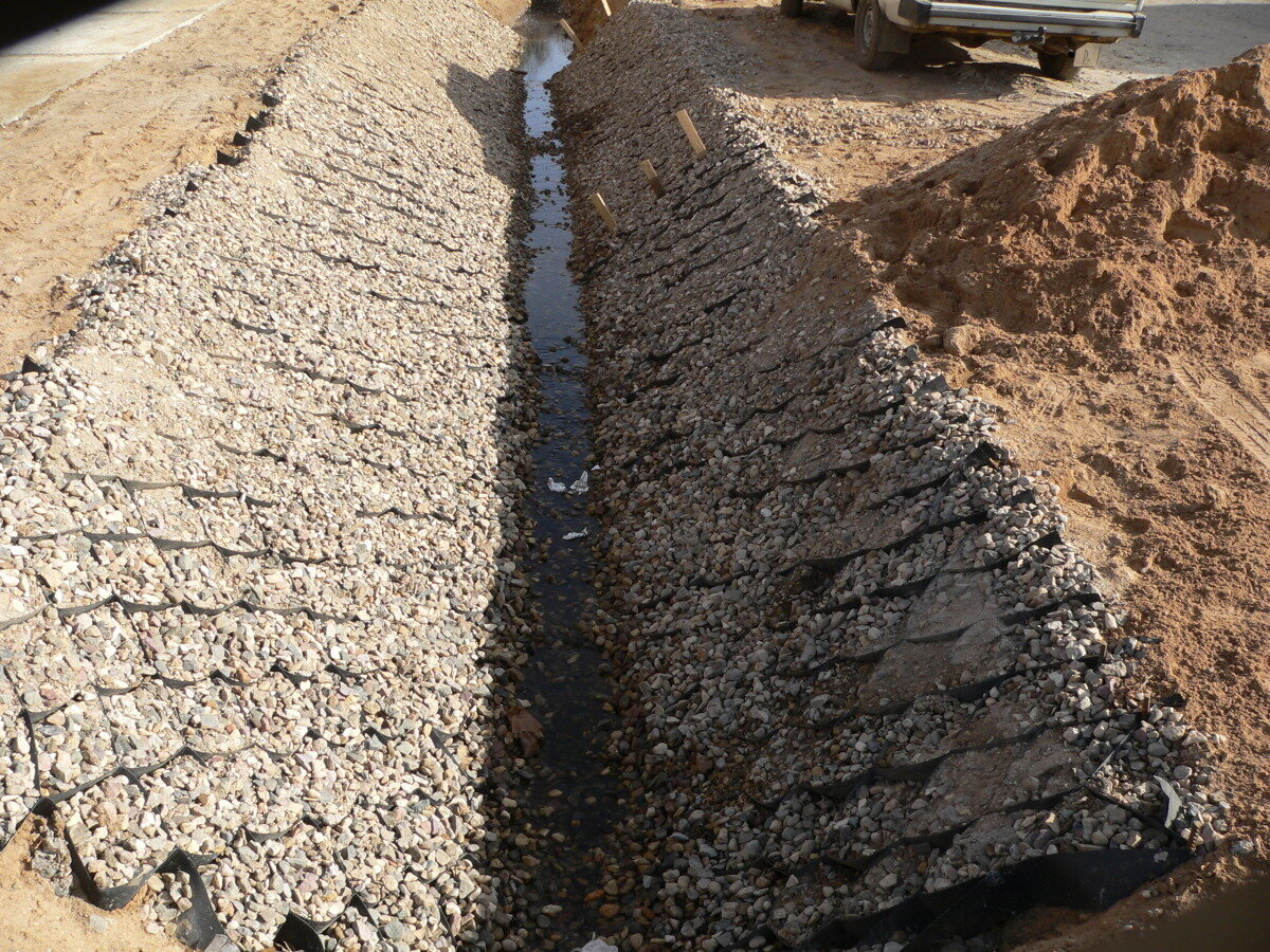 Временная дорога на участке. Нагорные водоотводные канавы. Укрепление водоотводных канав. Георешетка для дренажной канавы. Дренажная водоотводная канава.