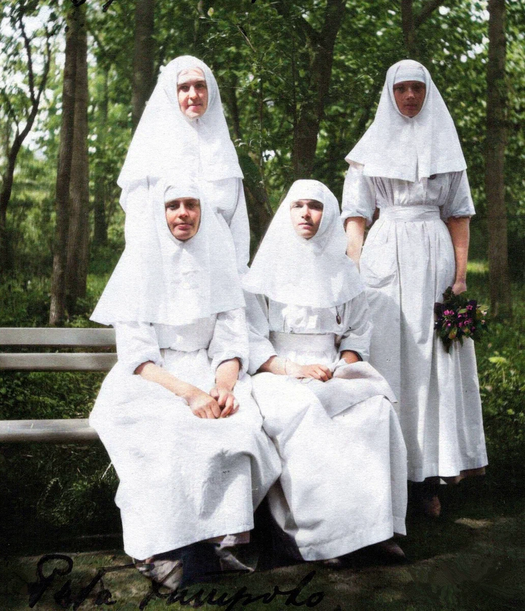 На лавочке сидит Маргарита (Рита) Хитрово, Великая княжна Ольга и рядом стоит Татьяна с цветами