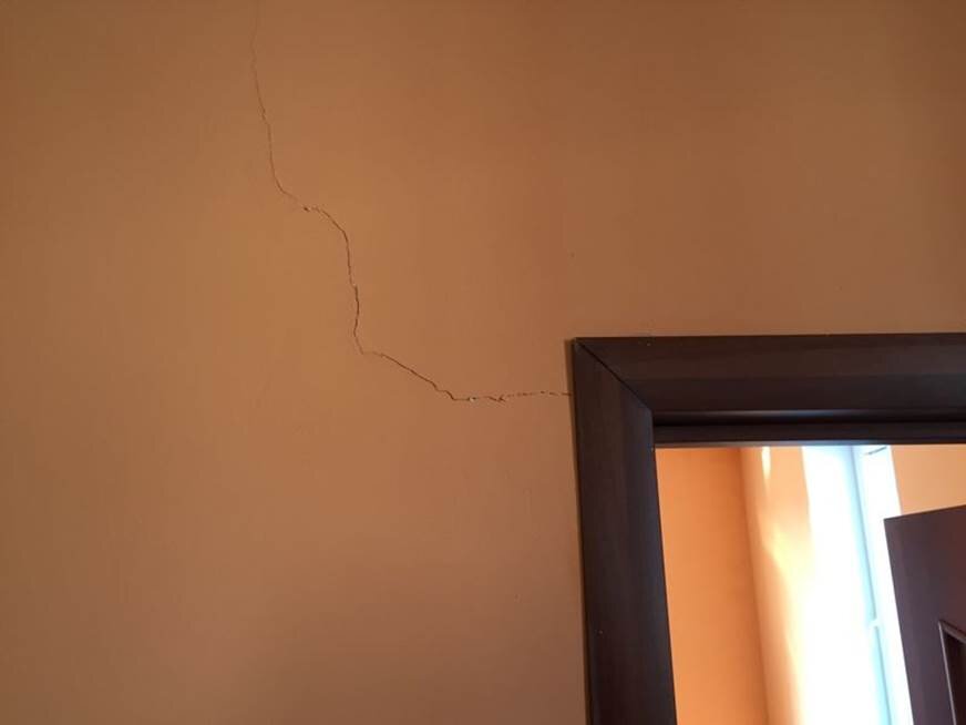 На стене появились трещины. Трещина в стене. Трещина в стене в квартире. Трещины в перегородках. Горизонтальные трещины в стене.