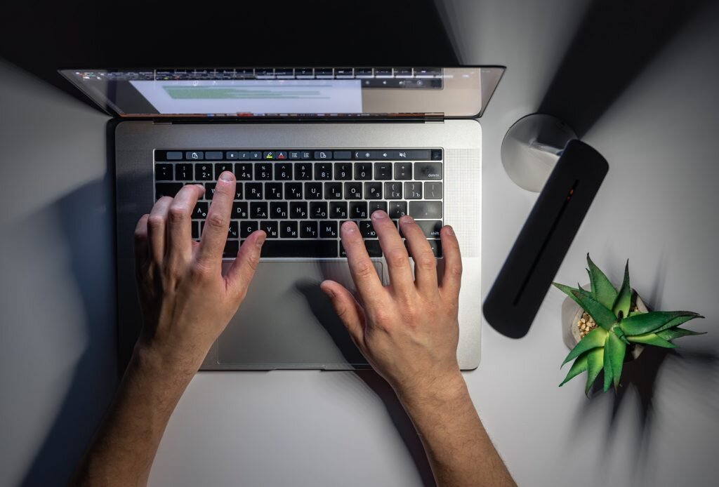    A man uses a laptop at night, hands close-up, night work, computer addiction, top view. Дмитрий Смирнов