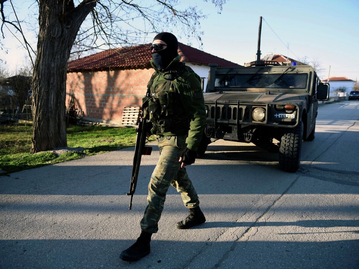    Офицер греческой армии в населенном пункте на греко-турецкой границе© AP Photo / Giannis Papanikos