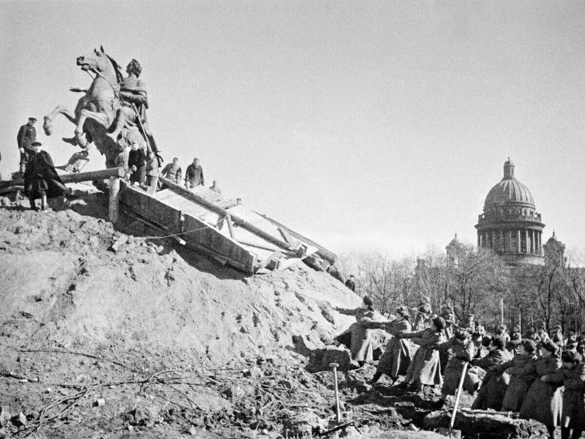    27 января 1944 года закончилась героическая оборона города на Неве, продолжавшаяся 872 дня. После снятия блокады Ленинграда, жители города освобождают памятник Петру l от защитных укрытий© РИА Новости / Давид Трахтенберг