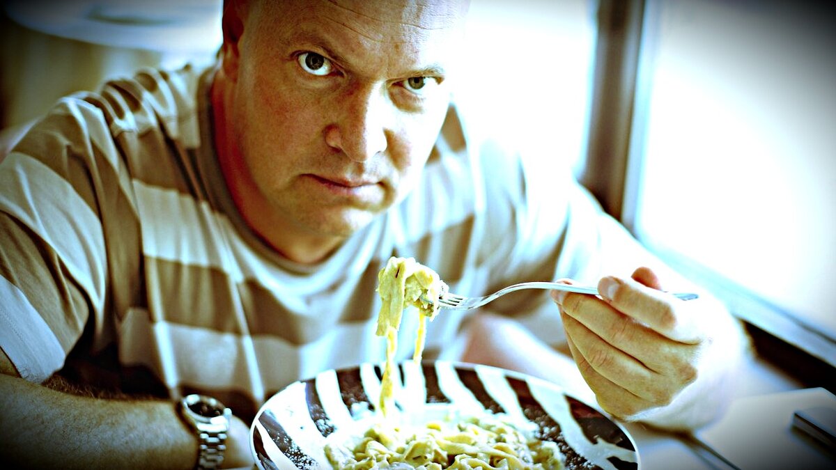 мужчина ест макароны