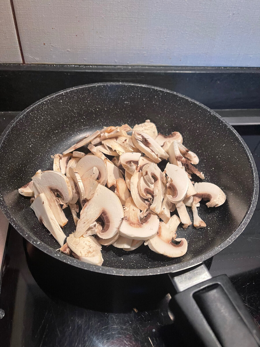 Нарезаем мелко шампиньоны. И тушим под крышкой без масла.