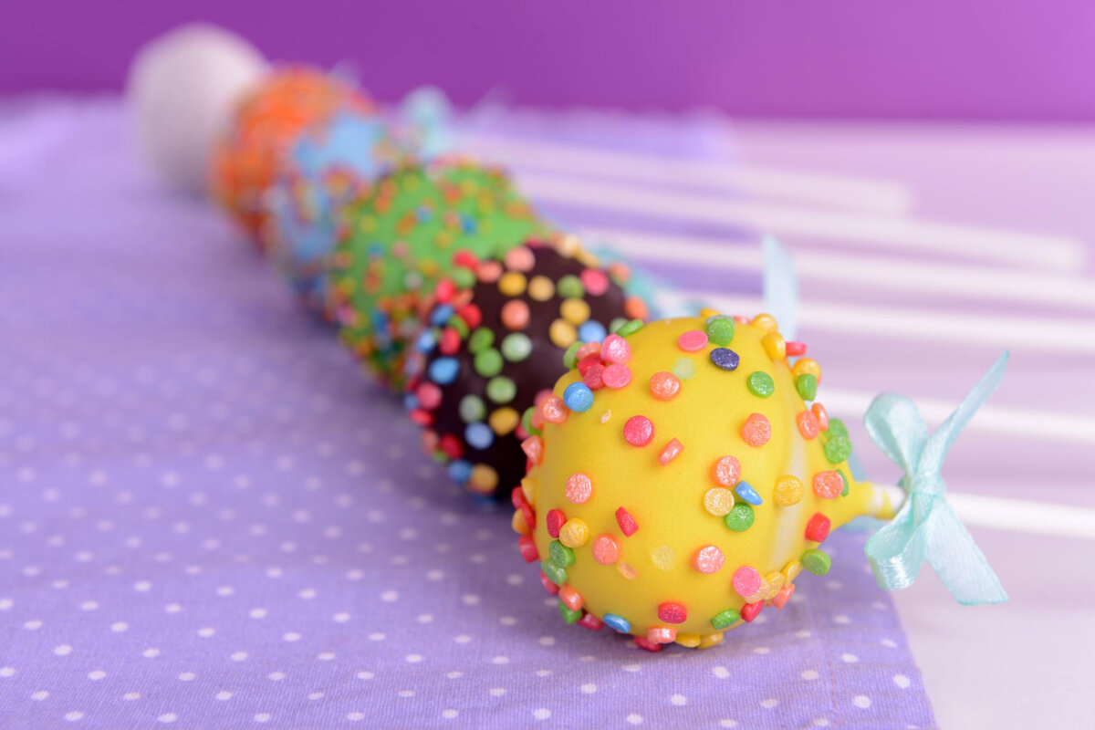 Cake Pops представляет собой десерт напоминающий чупа-чупс. Проще говоря, кейк-попс — это маленькое бисквитное пирожное, чем-то похожее на нашу «картошку», у которого есть своя оригинальность.