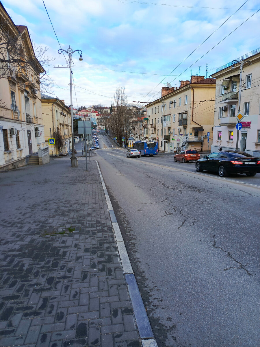 Нам нужно налево, между домами, где знак пешеходного перехода.