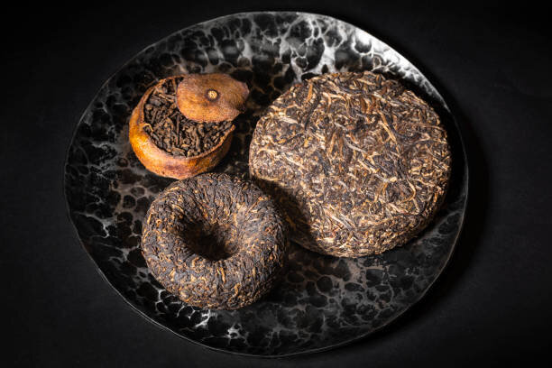 https://media.istockphoto.com/id/1488004434/photo/asian-pressed-pu-erh-tea-and-shu-puer-in-tangerine-on-dark-slate-background-copy-space.jpg?s=612x612&w=0&k=20&c=i-7WhUa9TgNXAFH6oLp9QfLG-4dcaDZO24ECwqq9Os8=