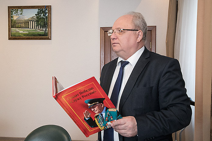 Сергей  Канунников держит в руках книгу, подаренную Героем Советского Союза  Дмитрием Бакуровым с дарственной подписью. Фото: Михаил Периков