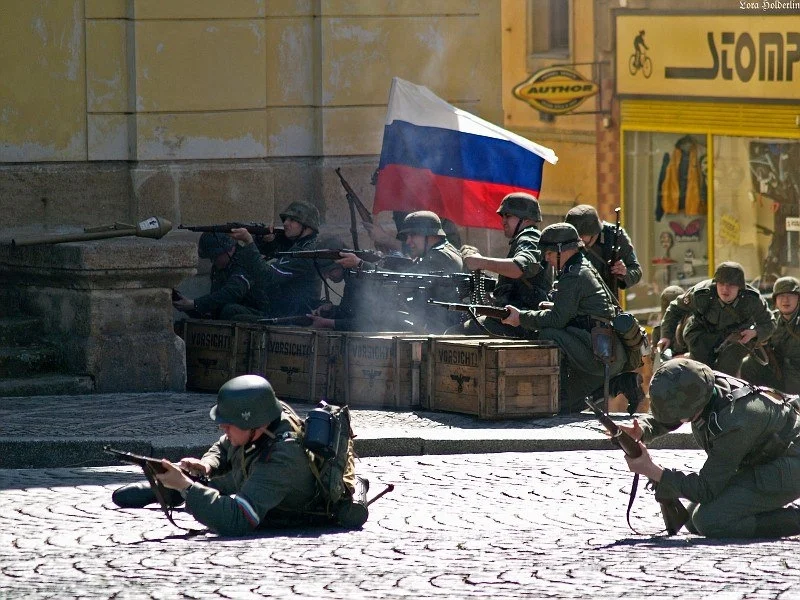 Власовцы ведут бой в Праге, май 1945 г. Реконструкция. Обратите внимание на флаг и на трёхцветную повязку у одного бойца. К ней мы ещё вернёмся.