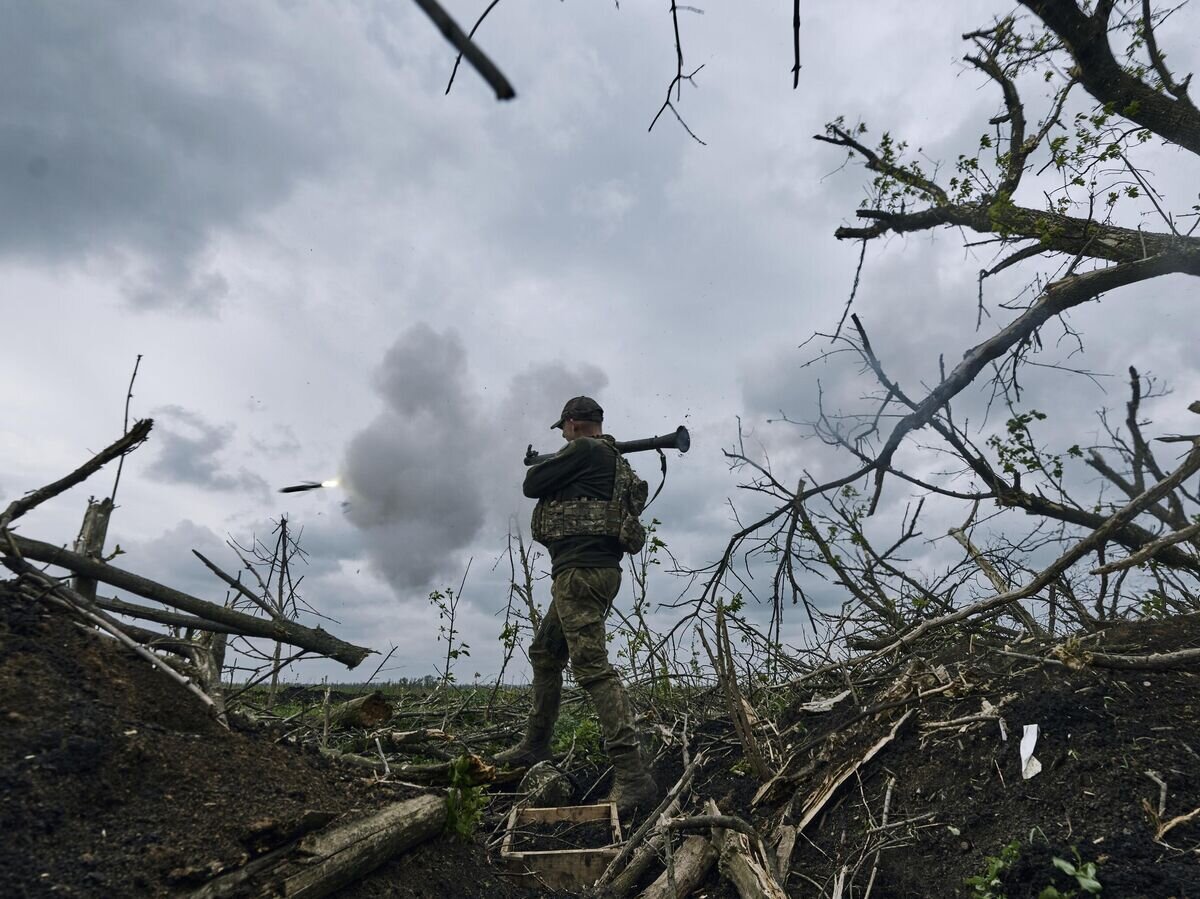    Украинский солдат стреляет на линии фронта возле Авдеевки© AP Photo / Libkos