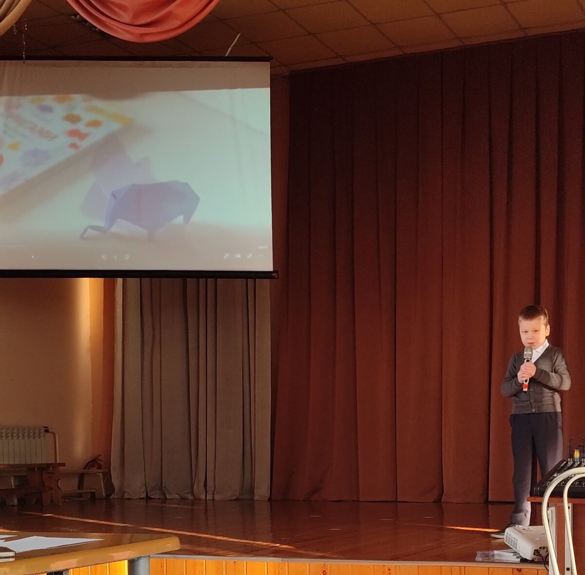 Паша на сцене рассказывает про оригами