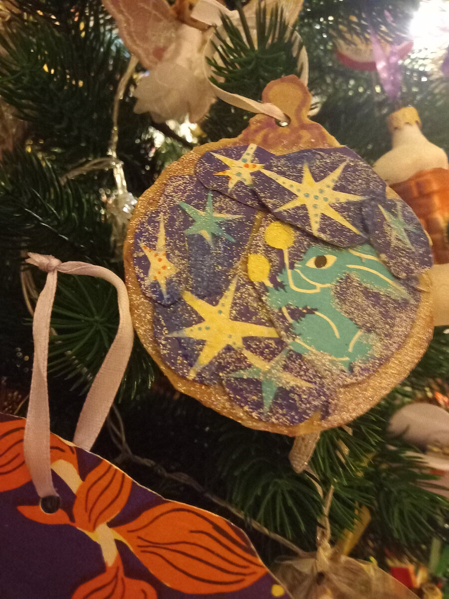 Шар "Кролик с маракасами". Его я покрыла лаком для ногтей, чтобы он был красивым и блестящим. Основу для шара, на которую наклеены кролик и звезды, я вырезала из картона. А звёзды, как и сам кролик, были вырезаны из игры.