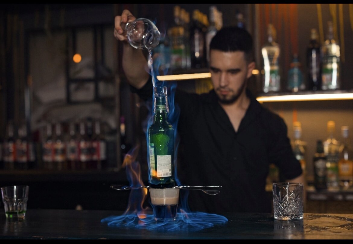 Бармен в кафе. Барная стойка с барменом. Коктейли на барной стойке. Барная стойка с барменом. Эрик бармен.