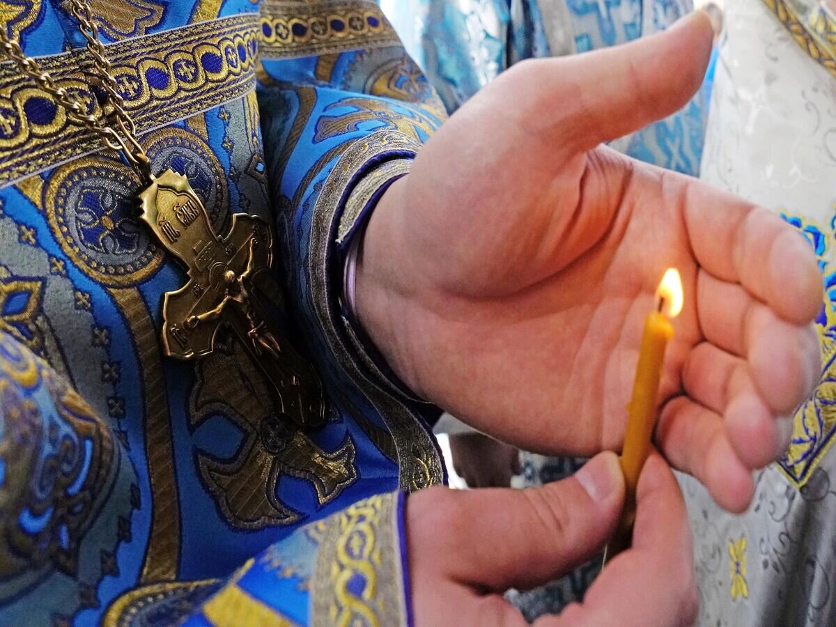  Свеча в руках священнослужителя в храме Сретения Господня© РИА Новости / Игорь Зарембо